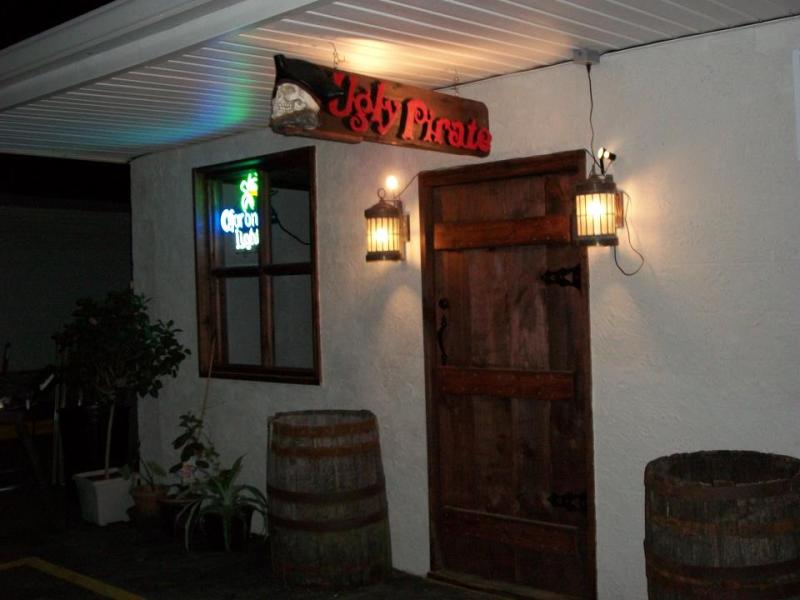 The Ugly Pirate entrance at night with rustic wooden door and lanterns